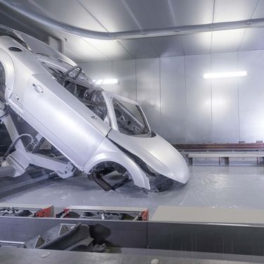 Audi R8 wird für die Grundierung durch ein Tauchbecken mit grauer Farbe gezogen